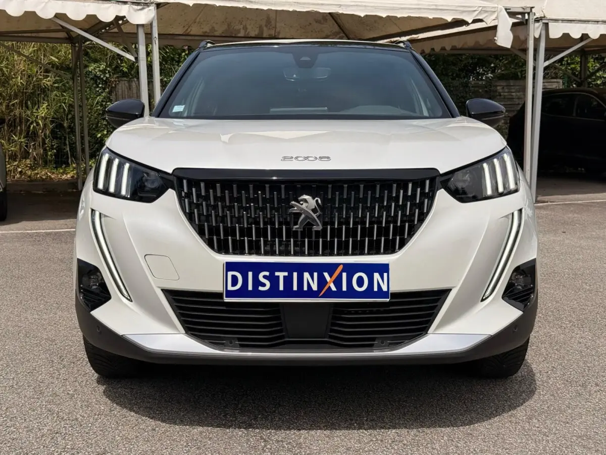 Vue avant d'un Peugeot 2008 blanc de 2021 avec calandre noire et feux LED verticaux distinctifs.