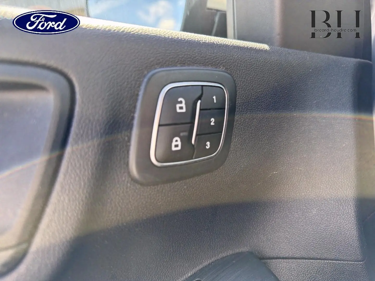 Détail du panneau de commandes de verrouillage sur la porte intérieure d'un Ford Kuga 2024 gris Solar Métallisé.