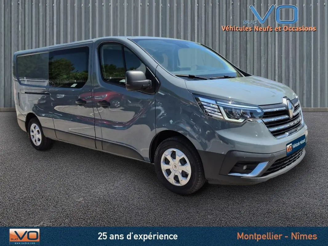 Renault Trafic Fourgon gris foncé vu en 3/4 avant droit avec vitres surteintées et porte latérale coulissante visible