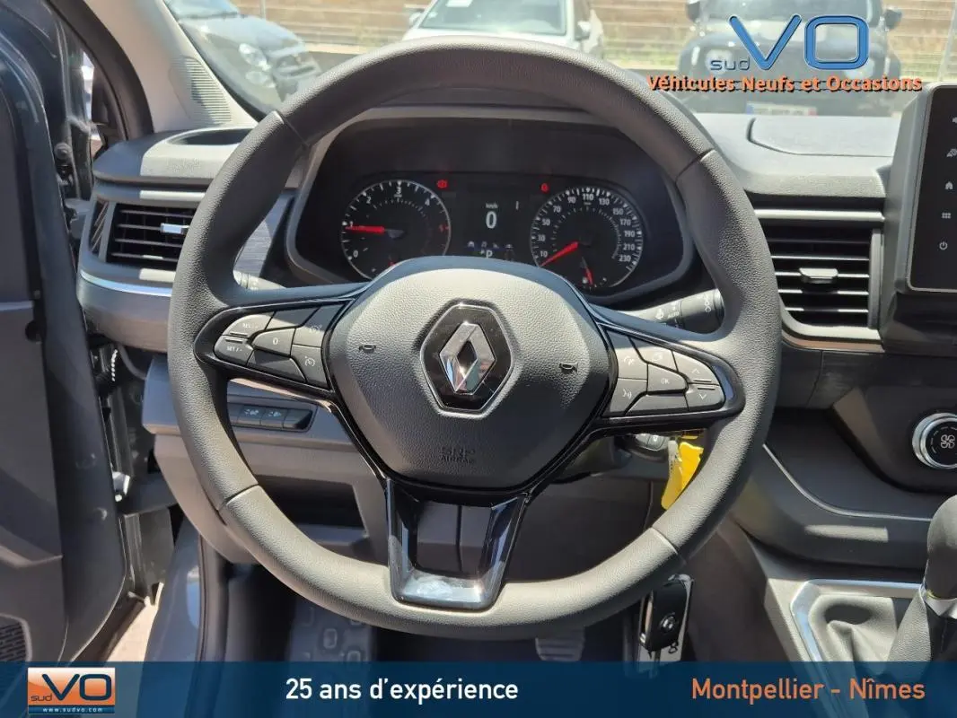 Vue centrée sur le volant noir du Renault Trafic Fourgon 2023 avec tableau de bord et commandes intégrées visibles.