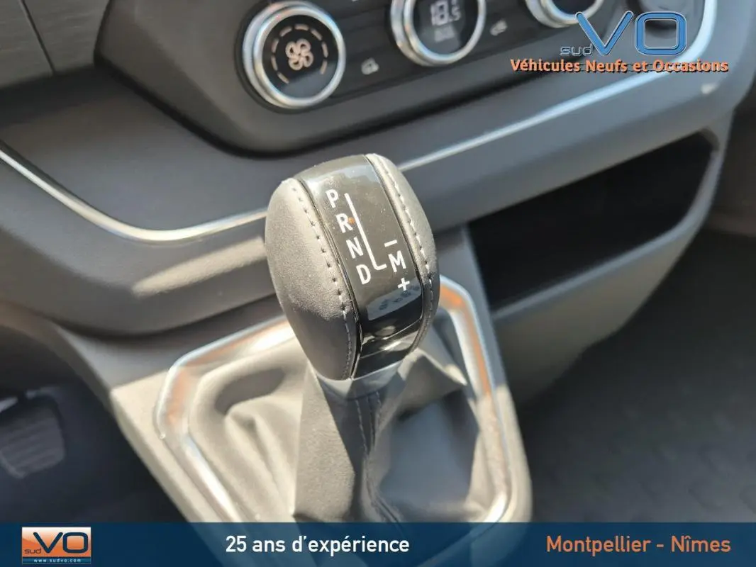 Le levier de vitesses automatique en cuir du Renault Trafic Fourgon gris foncé, vue rapprochée de la console centrale.