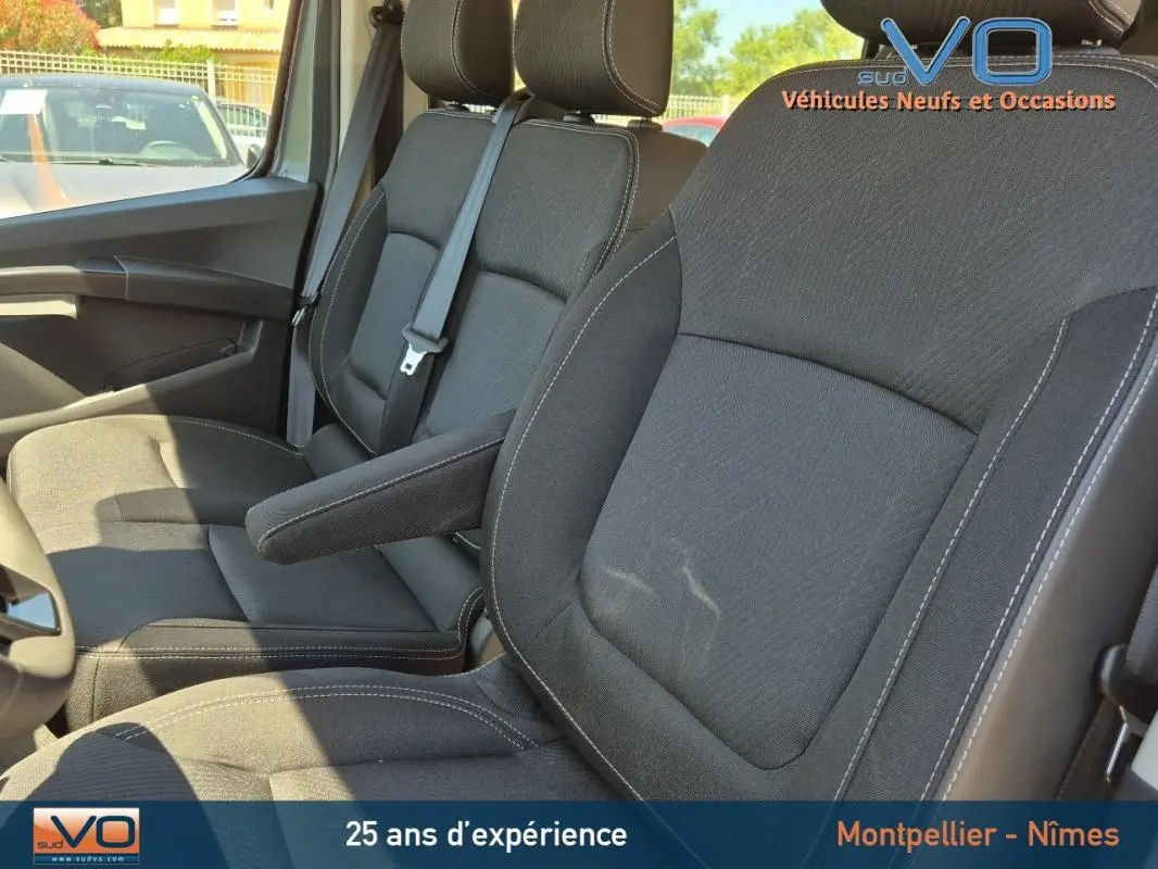 Vue rapprochée des sièges avant noirs du Renault Trafic Fourgon 2023, cabine approfondie, côté conducteur visible.