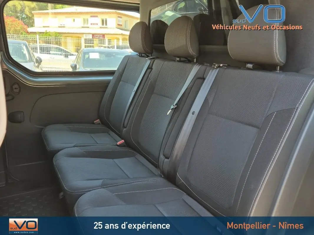 Banquette arrière en tissu gris foncé du Renault Trafic Fourgon 2023, vue latérale côté droit avec ceintures visibles.