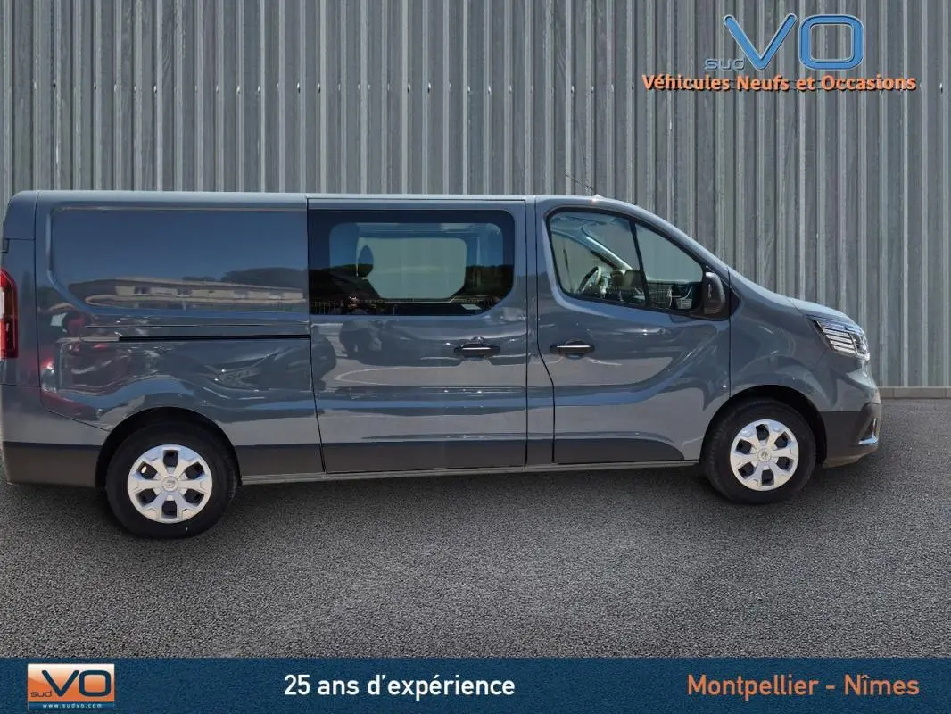 Profil côté gauche d’un Renault Trafic Fourgon gris foncé 2023 avec porte latérale vitrée et jantes acier.