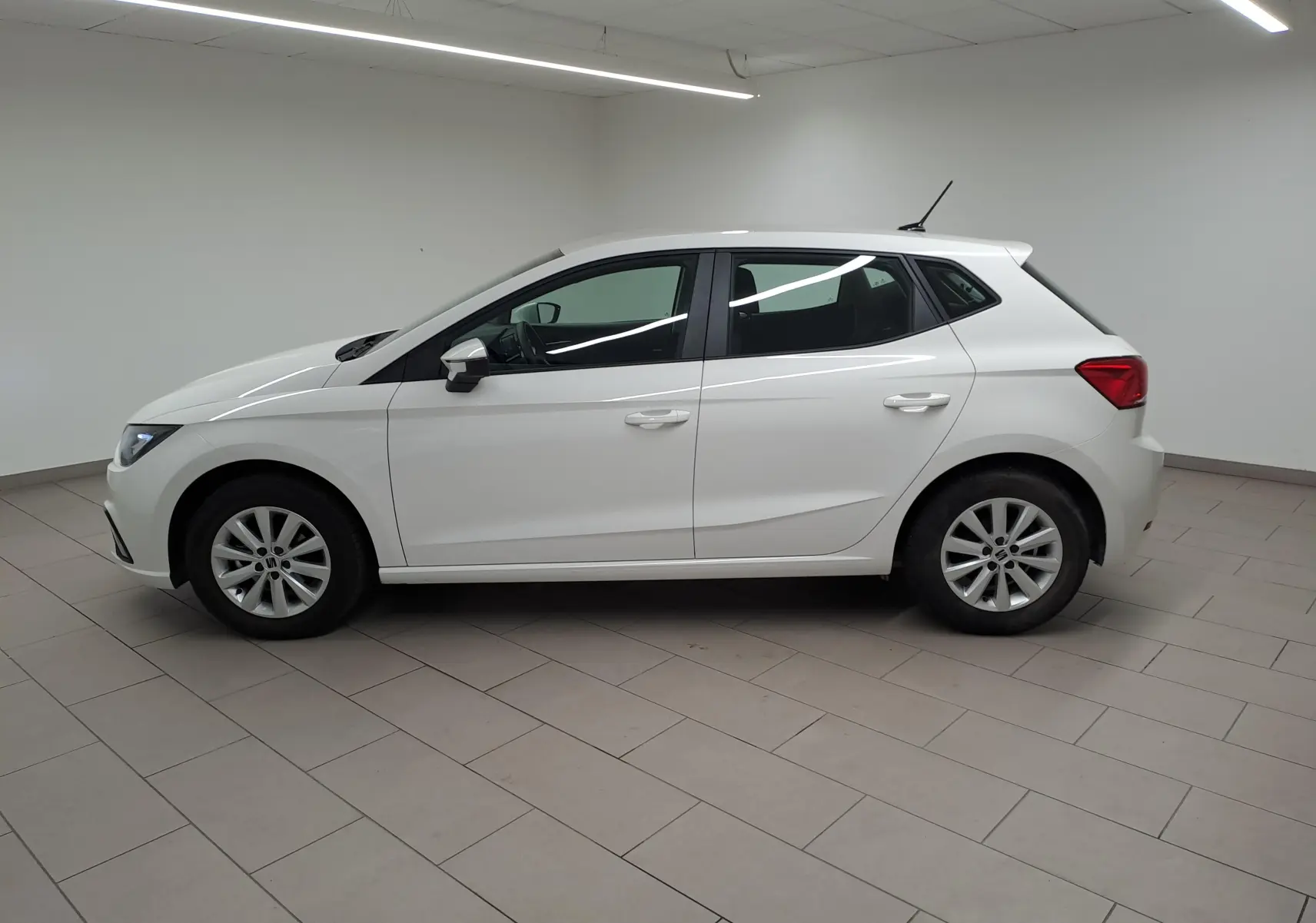 Vue latérale gauche d'une SEAT Ibiza 2023 blanc candy, finition Style Business, avec jantes alliage et lignes épurées.
