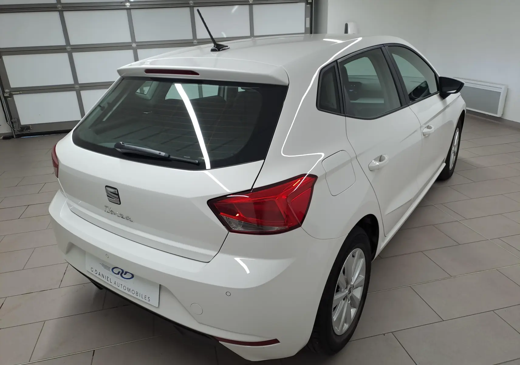 SEAT Ibiza blanc candy vue 3/4 arrière droit dans un garage, avec feux arrière rouges et jantes alliage.
