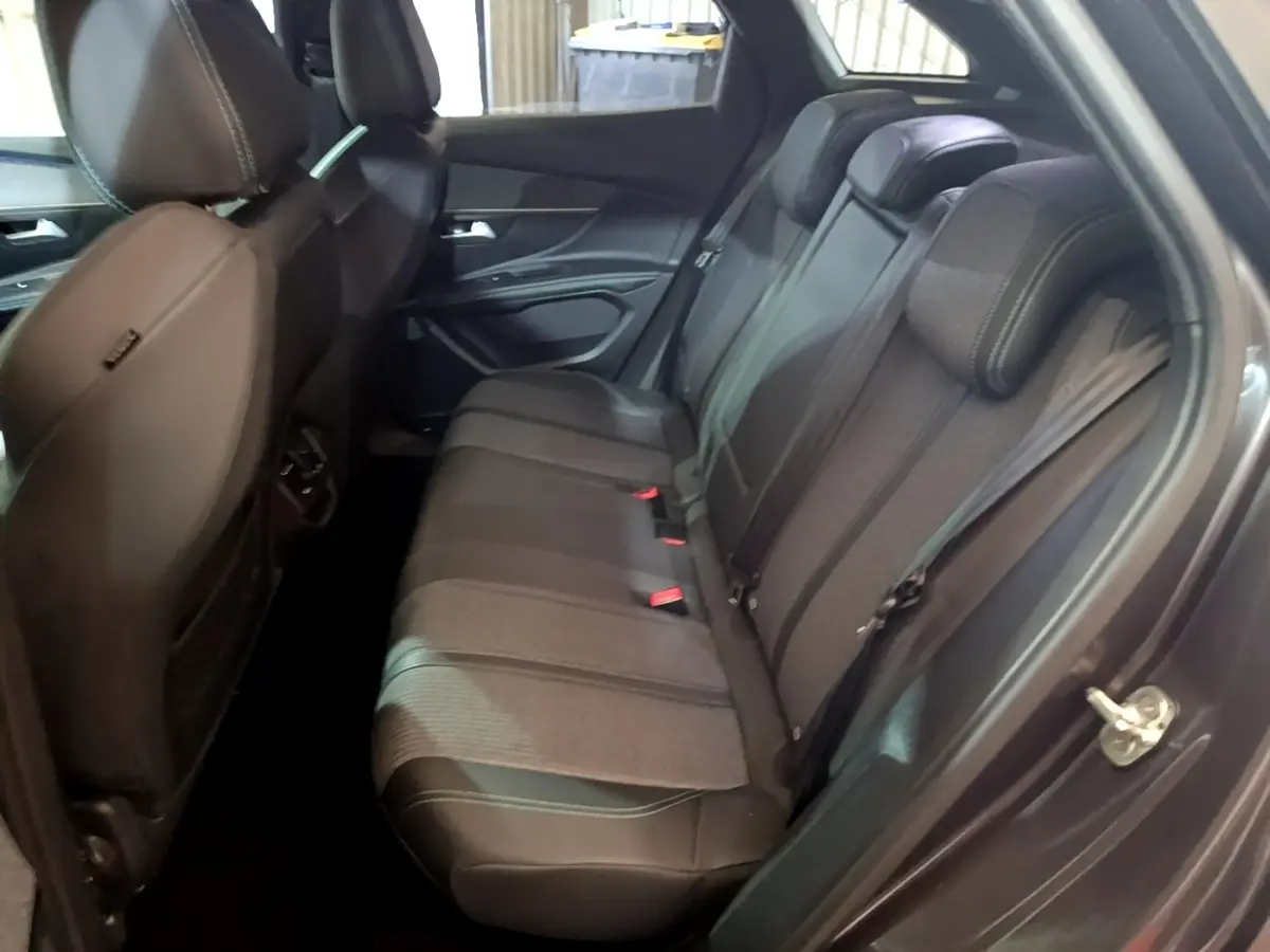 Vue côté droit de l'intérieur arrière gris foncé du Peugeot 3008 2022 avec sièges en cuir et tissu bicolore.