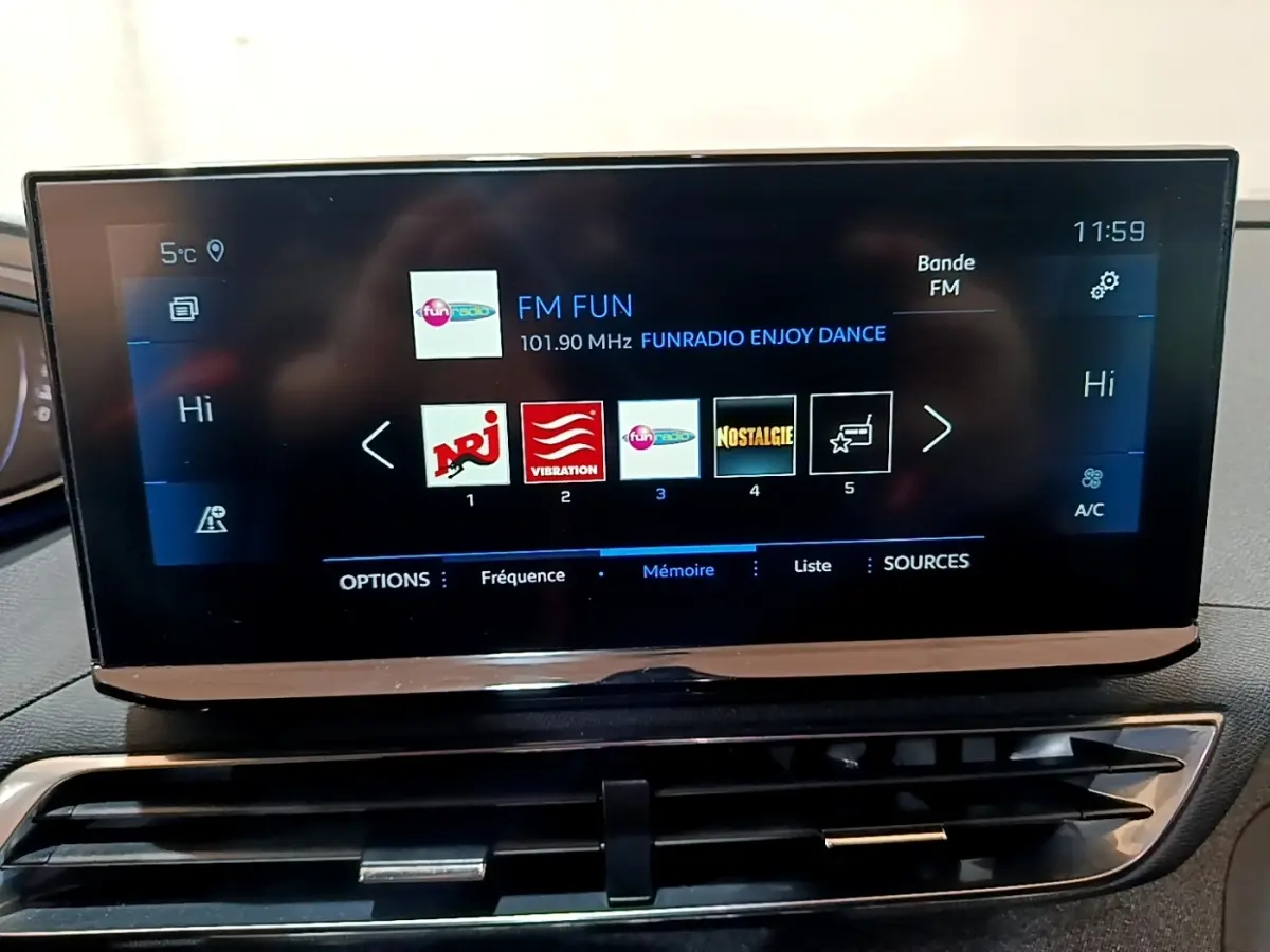 Écran tactile central du tableau de bord du Peugeot 3008 gris foncé affichant les stations radio FM.