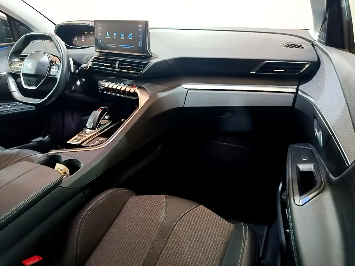 Intérieur du Peugeot 3008 2022 gris foncé, vue côté passager montrant tableau de bord et écran tactile central.