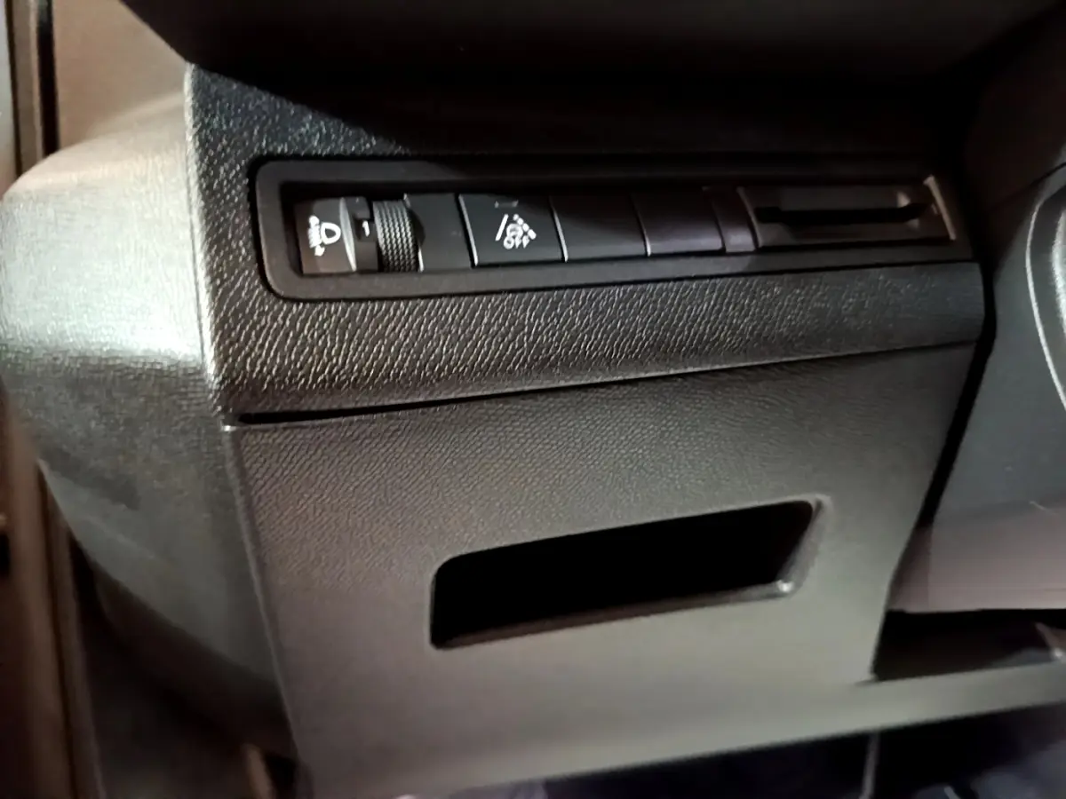 Détail du tableau de bord noir côté gauche avec commandes d'éclairage sur Peugeot 3008 gris foncé 2022