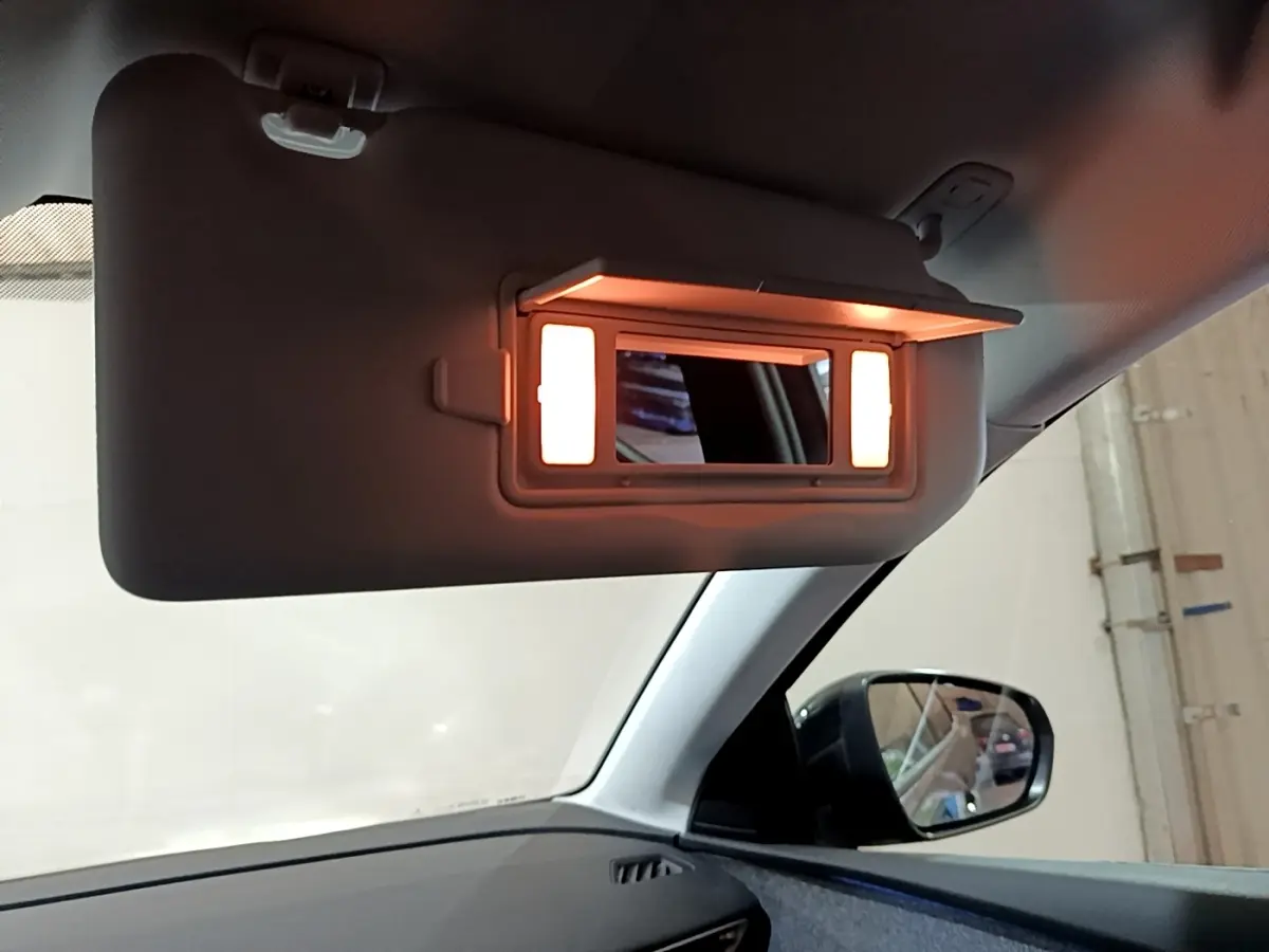 Miroir de courtoisie éclairé sur pare-soleil côté conducteur dans l'habitacle du Peugeot 3008 gris foncé 2022.