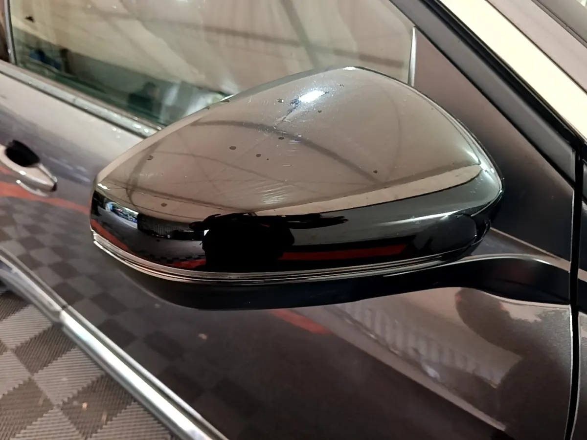 Rétroviseur droit noir brillant sur Peugeot 3008 gris foncé, vue rapprochée côté conducteur.