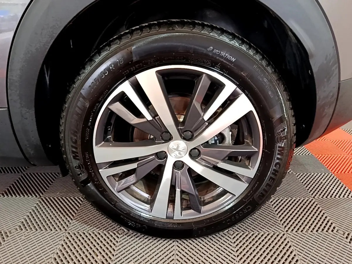 Gros plan sur la roue avant droite gris foncé du Peugeot 3008 avec jante alliage et pneu Michelin visible.