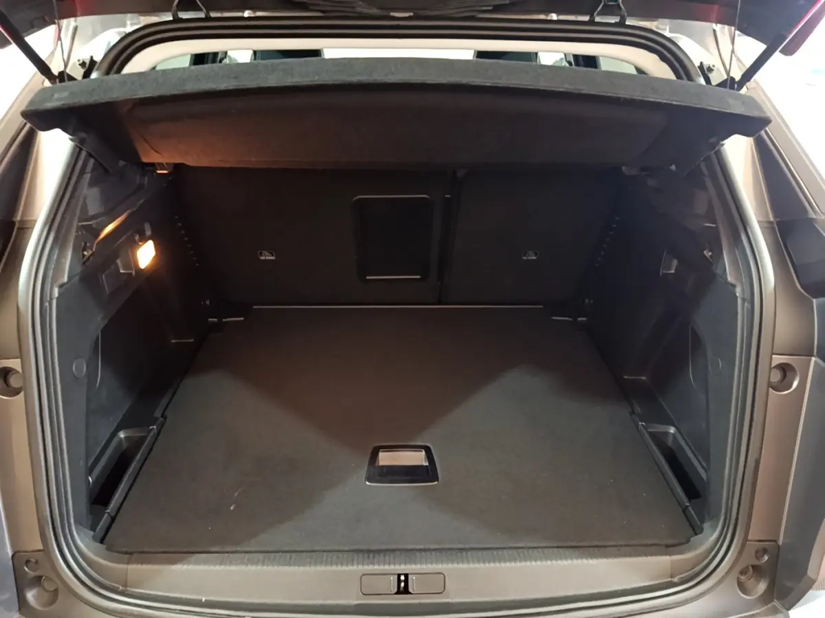 Coffre ouvert d’un Peugeot 3008 gris foncé, vue arrière montrant l’espace de chargement vide et la tablette cache-bagages.