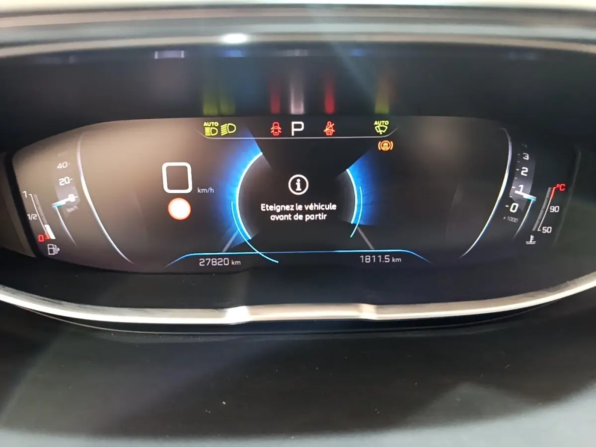 Tableau de bord numérique du Peugeot 3008 gris foncé, affichant un message d'arrêt avant départ.