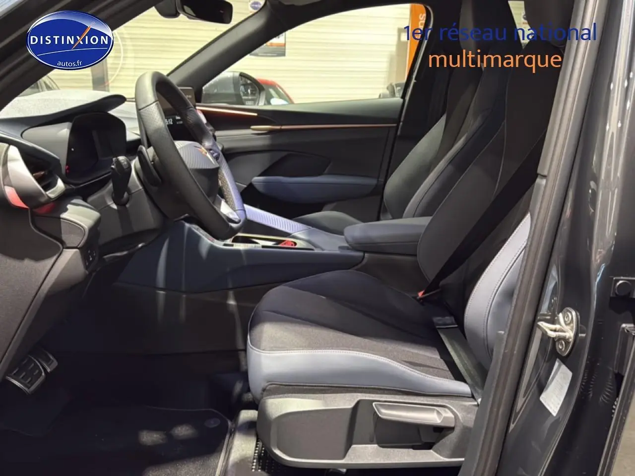 Vue intérieure côté conducteur d'une CUPRA TERRAMAR gris avec sièges sport et volant cuir multifonction.