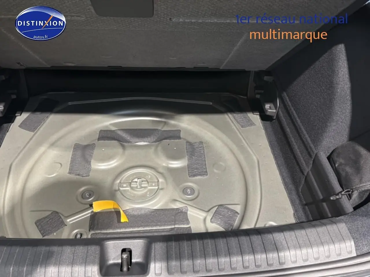 Vue plongeante sur le coffre ouvert d'une CUPRA TERRAMAR gris, montrant le compartiment à roue de secours vide.