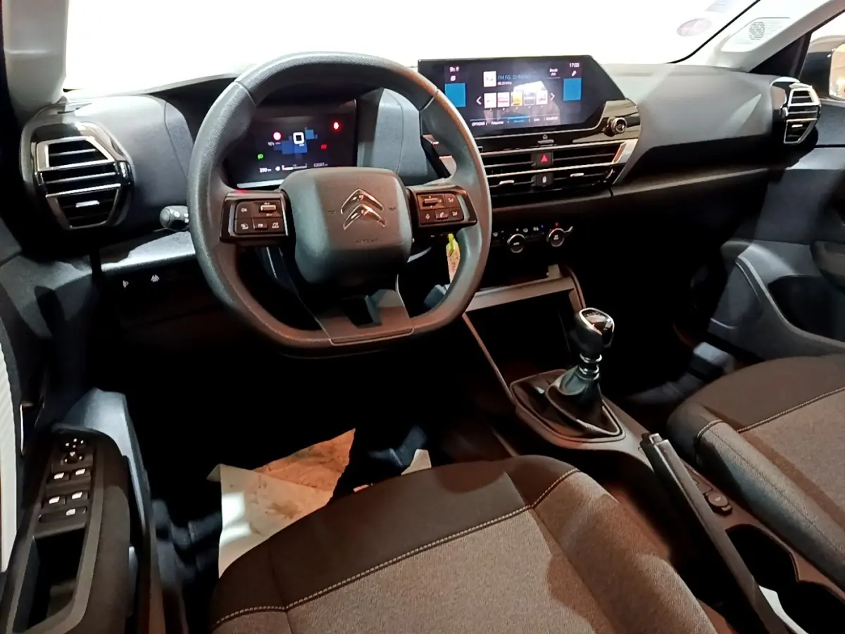 Vue intérieure avant de la Citroën C4 gris foncé 2021, volant multifonctions, écran tactile et boîte manuelle visible.