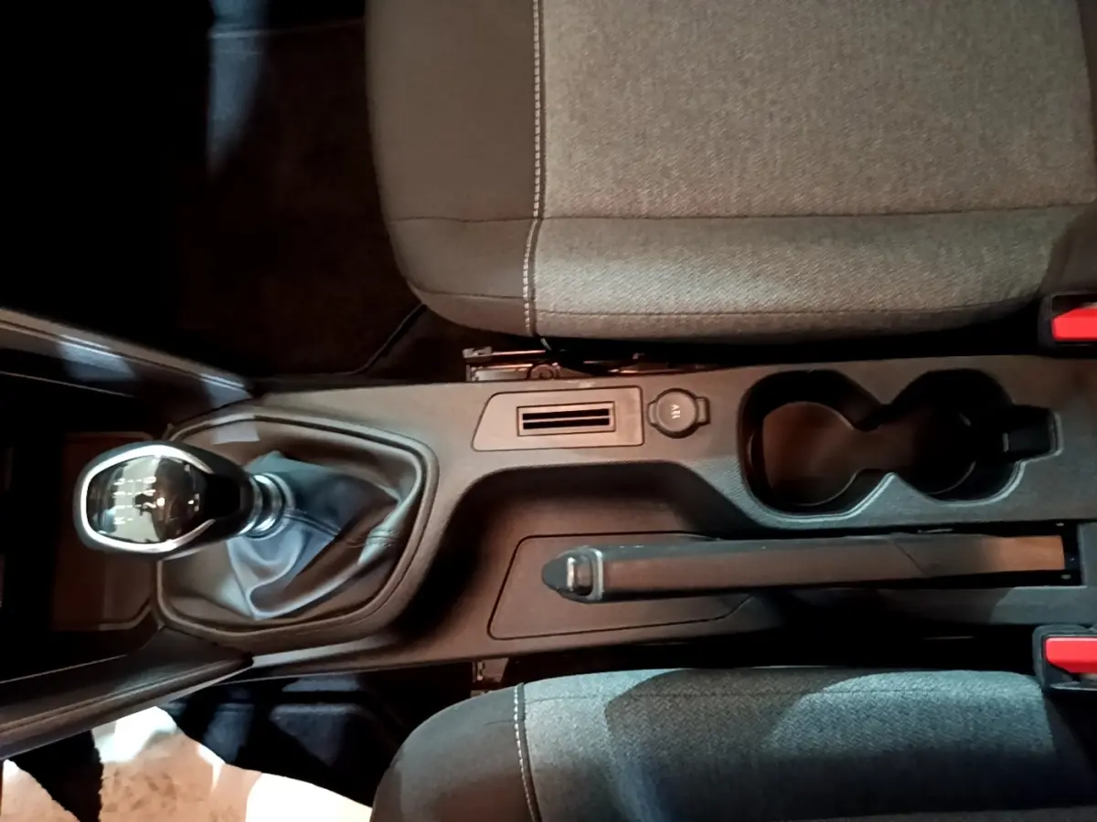 Vue plongeante sur la console centrale de la Citroën C4 gris foncé, avec frein à main manuel et porte-gobelets.