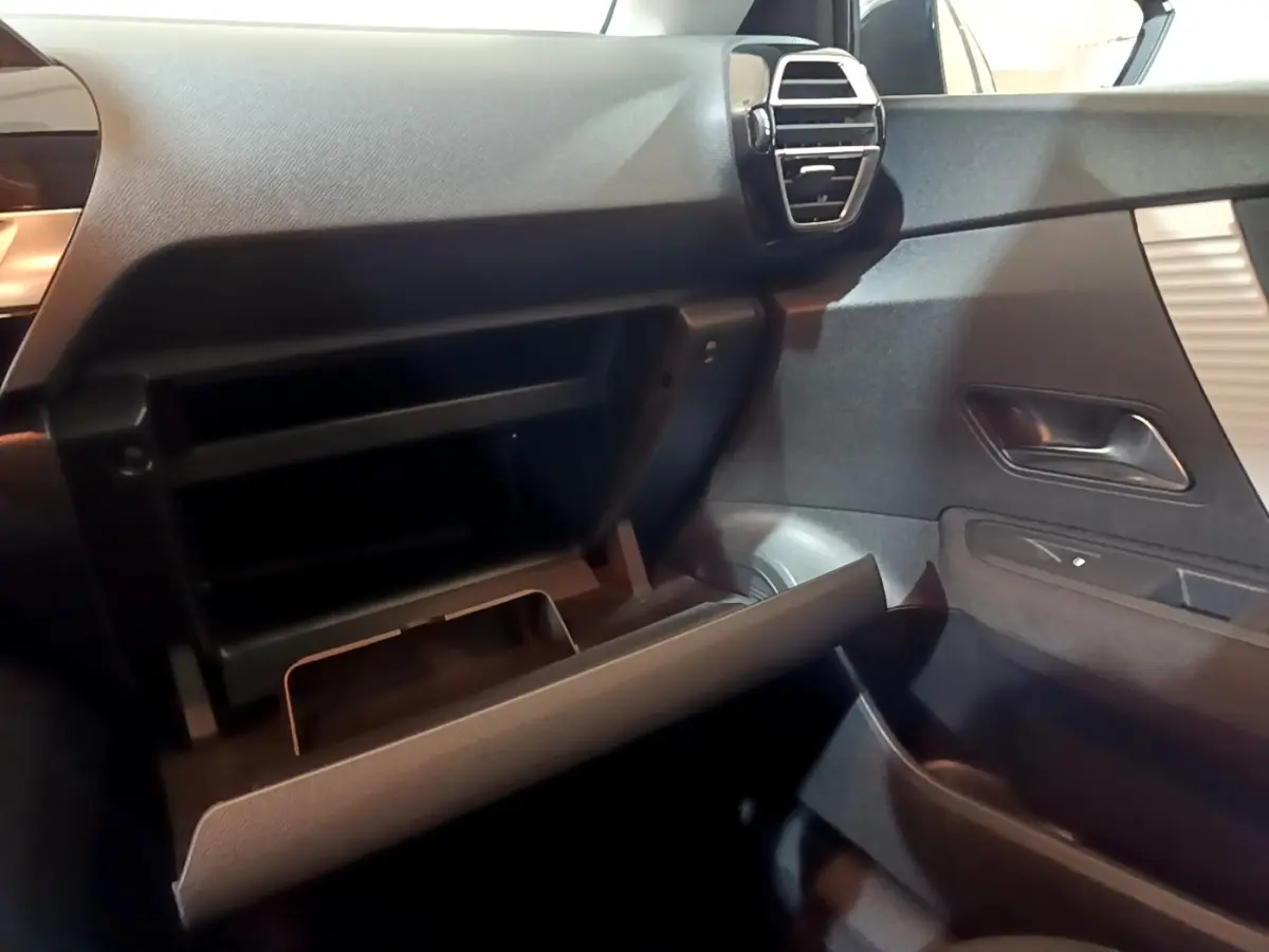 Intérieur de la Citroën C4 2021, vue côté passager sur la boîte à gants ouverte et la portière grise foncée.