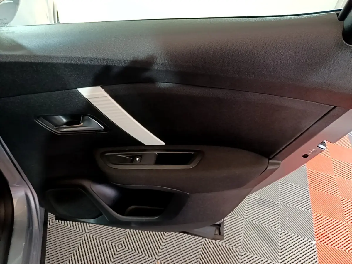 Vue rapprochée de la porte arrière gauche intérieure noire avec insert décoratif gris clair du Citroën C4 2021.
