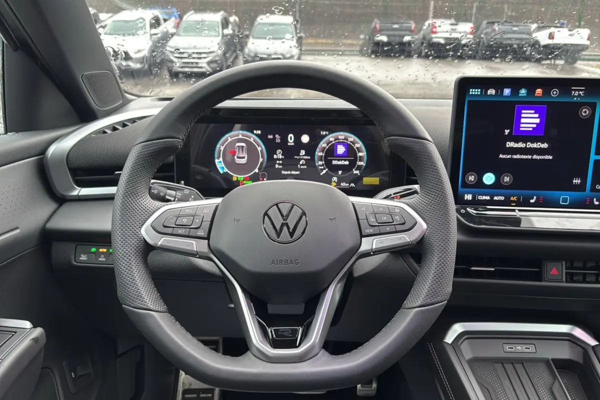 Vue centrée sur le volant cuir multifonctions du Volkswagen T-Roc 2026 avec tableau de bord digital et écran tactile.