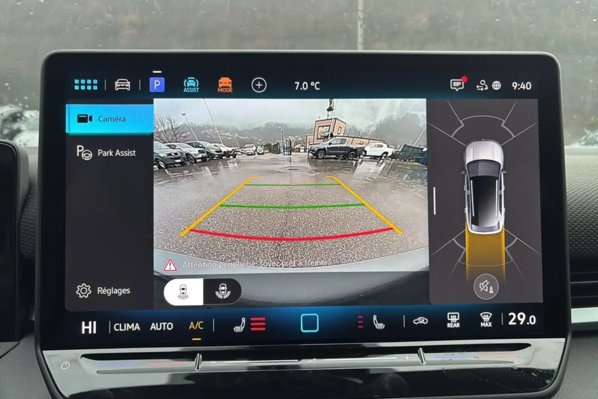 Écran de caméra de recul du Volkswagen T-Roc gris loup montrant une vue arrière avec lignes de guidage colorées.