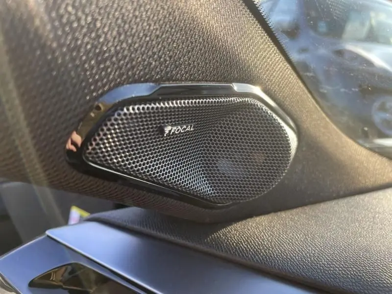 Gros plan sur l'enceinte Focal intégrée dans l'habitacle du Peugeot 408 Hybrid 2024, finition GT noir métal.