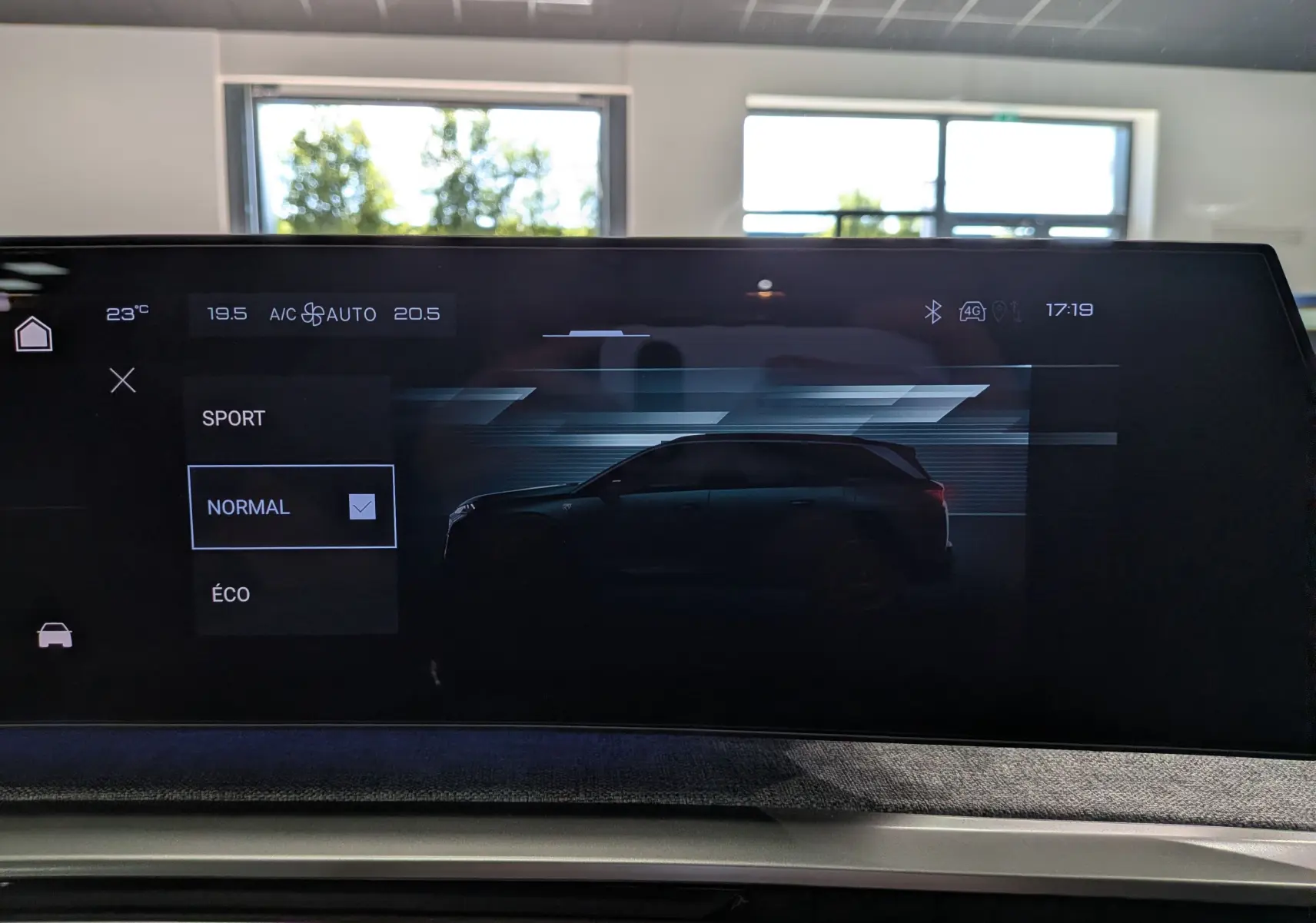 Écran tactile intérieur montrant la silhouette latérale gauche du Peugeot 5008 Hybrid gris titane avec toit noir en mode de conduite normal.