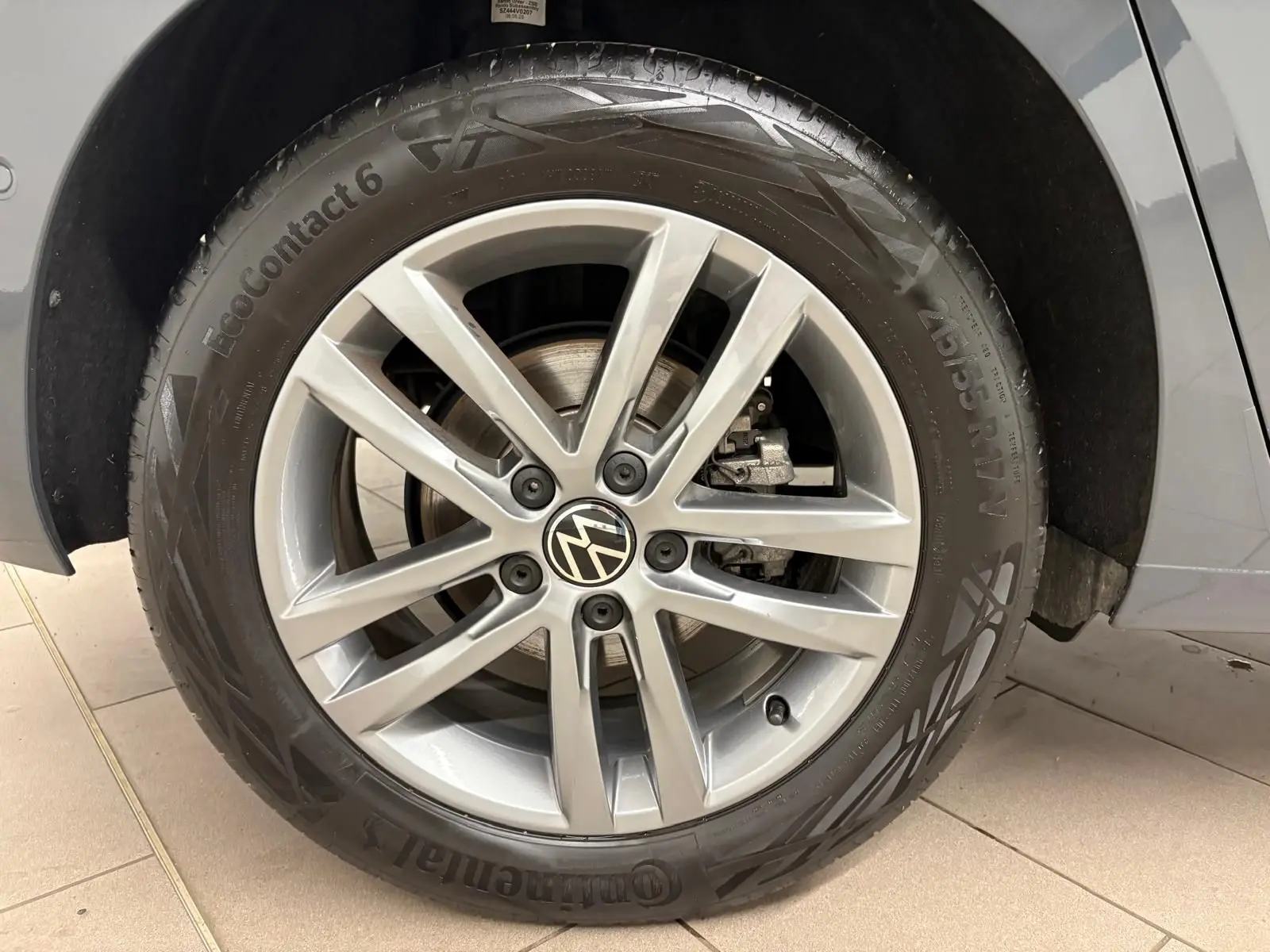 Gros plan sur la roue avant droite gris dauphin d’un Volkswagen Touran 2.0 TDI avec jante alliage 5 branches doubles.