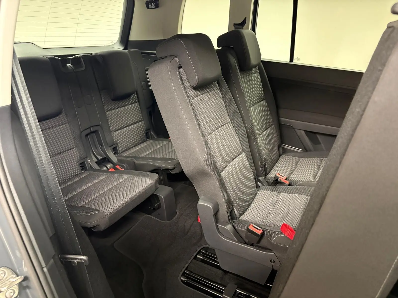 Vue intérieure côté droit sur les sièges arrière 7 places en tissu gris du Volkswagen Touran 2025.