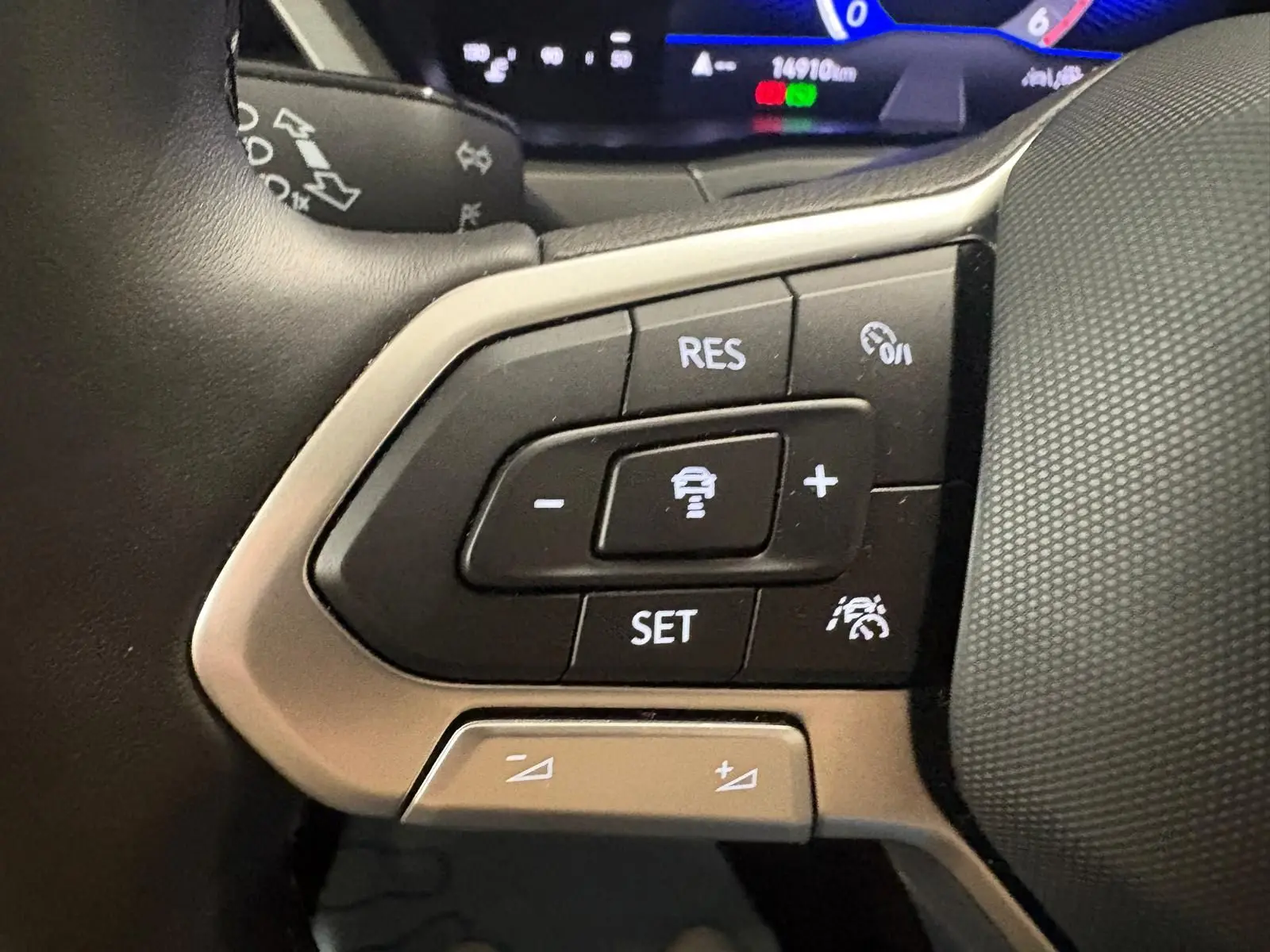 Gros plan sur les commandes au volant du Volkswagen Touran 2025, mettant en valeur les boutons de régulateur de vitesse.