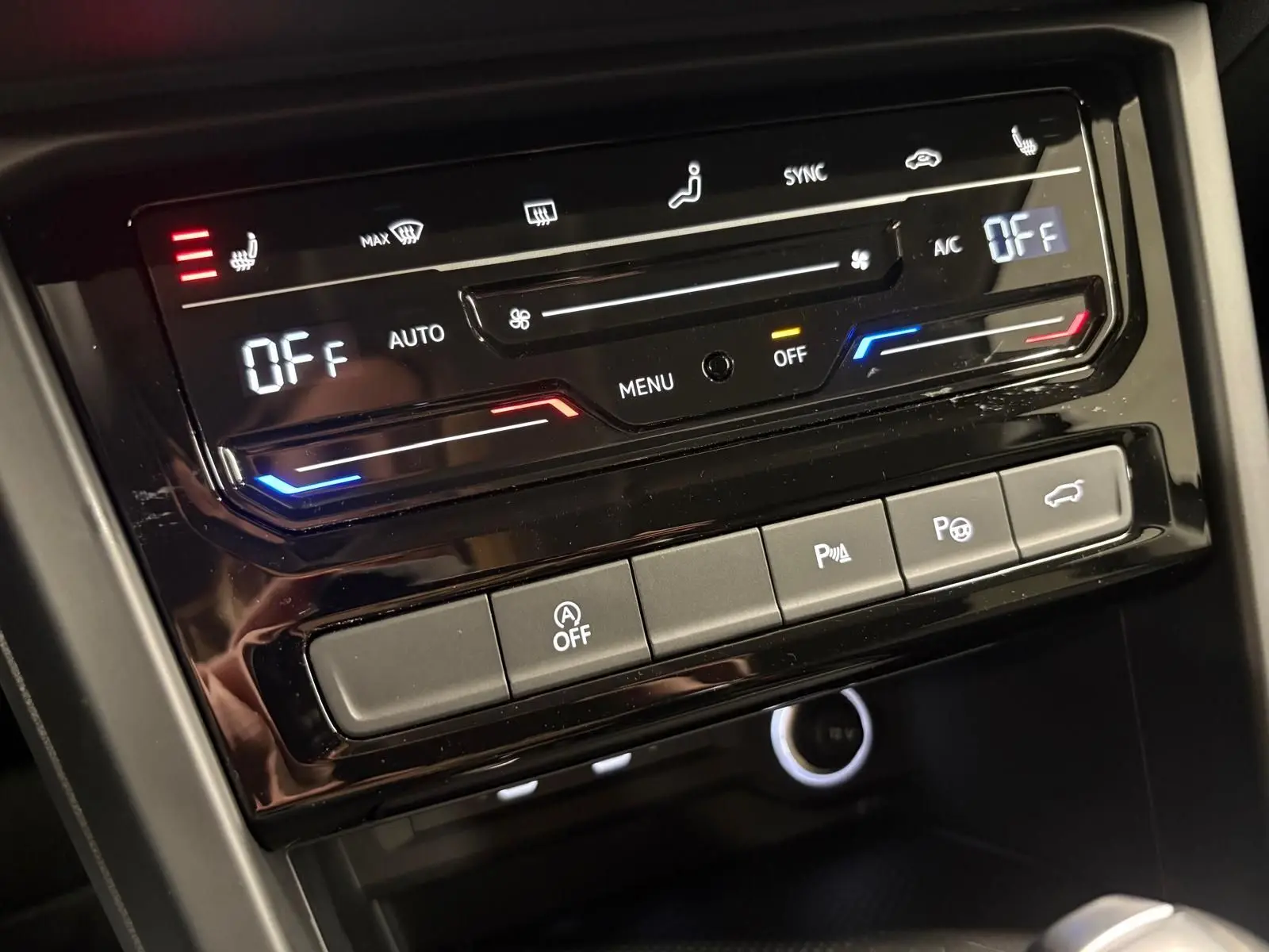 Panneau de commande de climatisation et assistances dans l’habitacle du Volkswagen Touran gris Dauphin, vue rapprochée.
