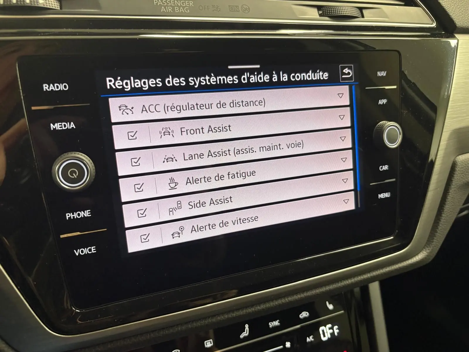 Écran tactile central du Volkswagen Touran 2025 montrant les réglages des aides à la conduite dans l'habitacle.
