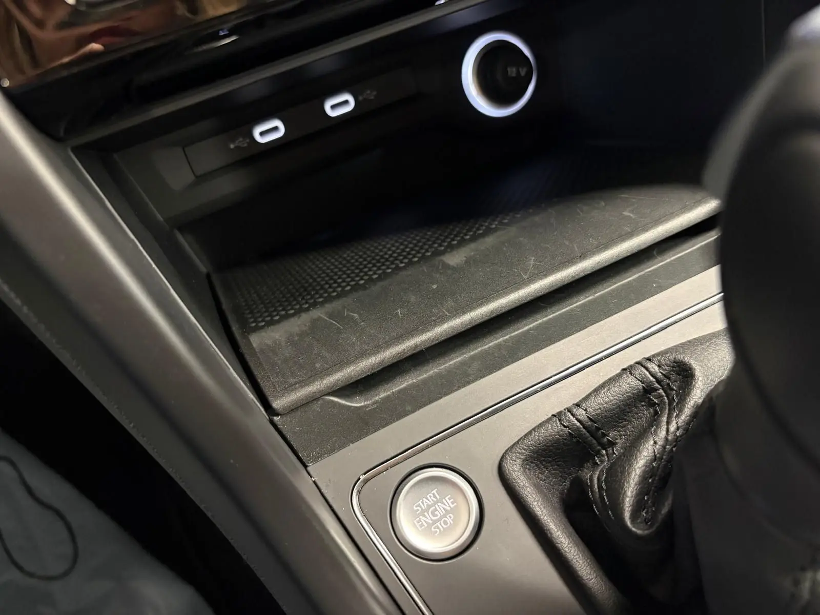 Gros plan sur la console centrale du Volkswagen Touran 2025, bouton Start Engine Stop et ports USB visibles.
