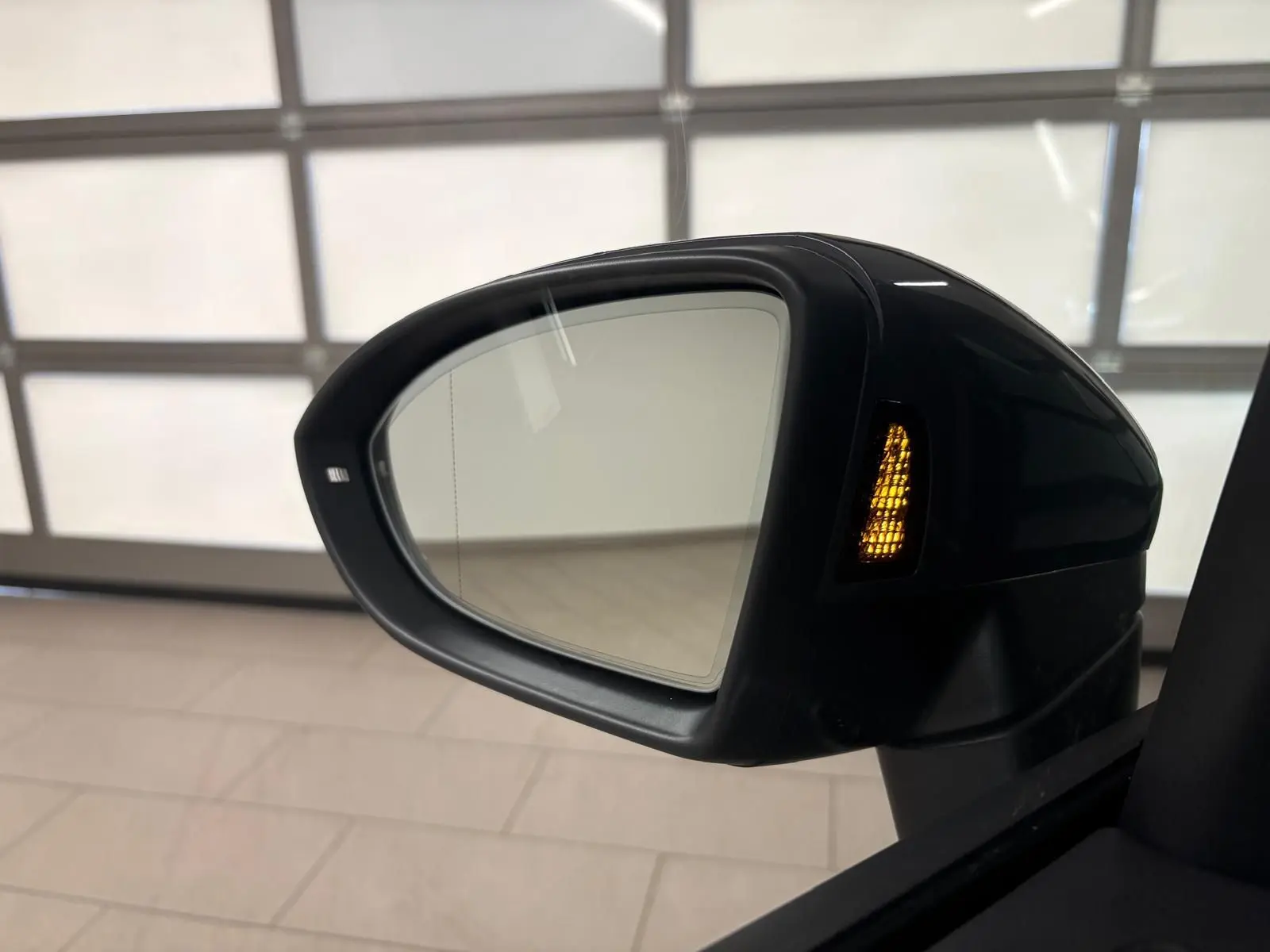 Rétroviseur droit allumé avec clignotant orange du Volkswagen Touran 2025 Gris Dauphin, vue rapprochée intérieure.