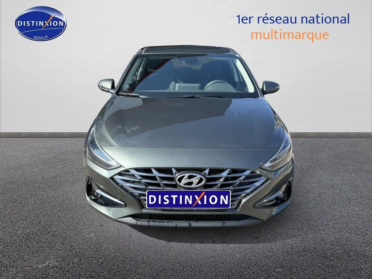 Vue frontale d'une Hyundai i30 gris anthracite 2024 avec calandre chromée et phares LED fins.