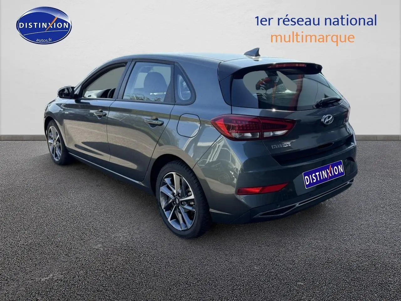 Vue 3/4 arrière droite d'une Hyundai i30 gris anthracite avec jantes alu et feux arrière LED visibles.