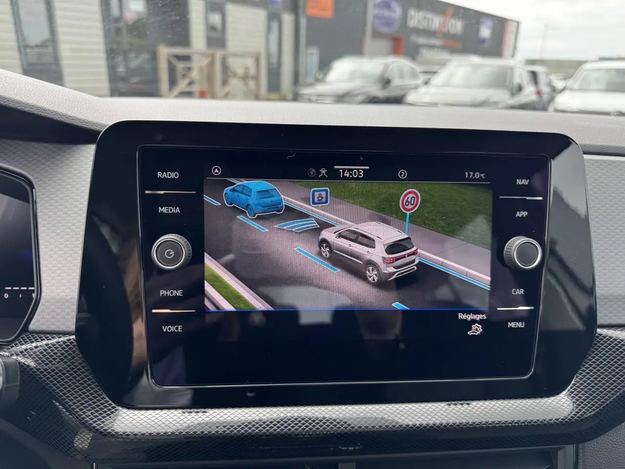 Écran central du Volkswagen T-Cross gris Ascot 2024 montrant l'assistance au maintien de voie et la limitation de vitesse à 60 km/h.