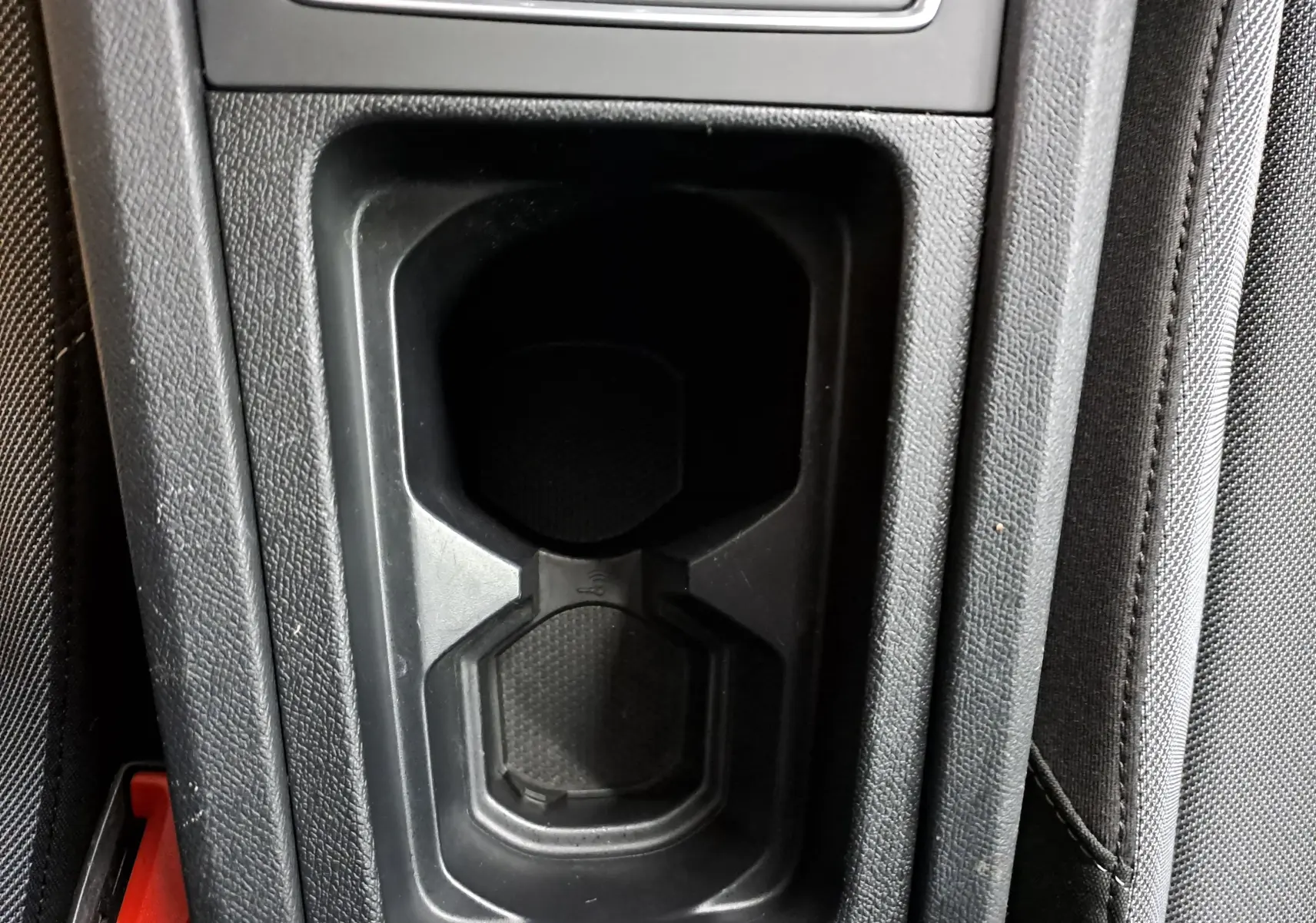 Vue plongeante sur le porte-gobelets central noir intérieur d'une SEAT LEON 1.5 eTSI Hybrid 2025 finition Style.