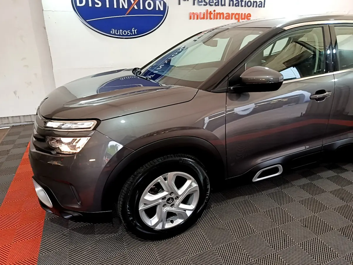 Vue 3/4 avant droit d'un Citroën C5 Aircross gris foncé avec jantes alliage et inserts Airbump argentés.