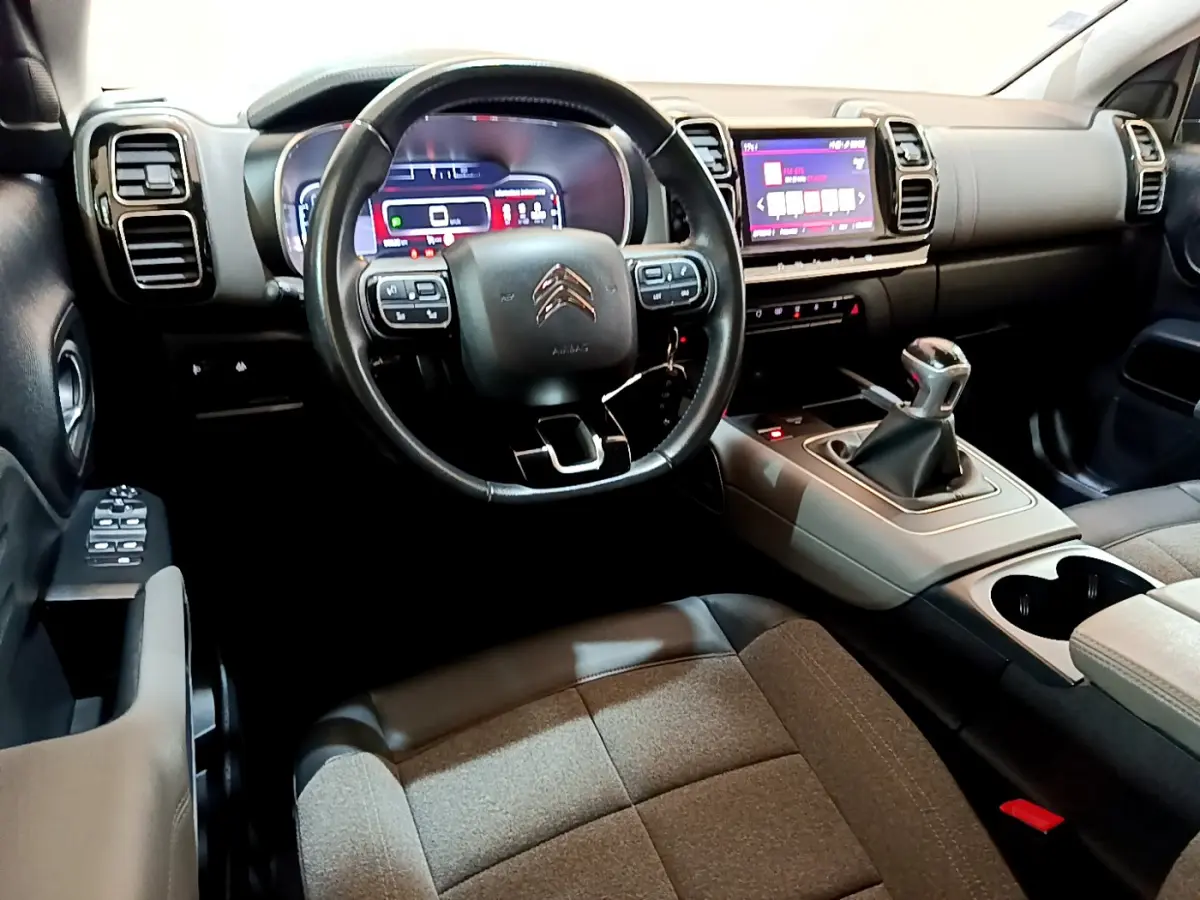 Vue intérieure côté conducteur du Citroën C5 Aircross 1.5 BlueHDi 130 avec volant cuir et levier de vitesse manuel.