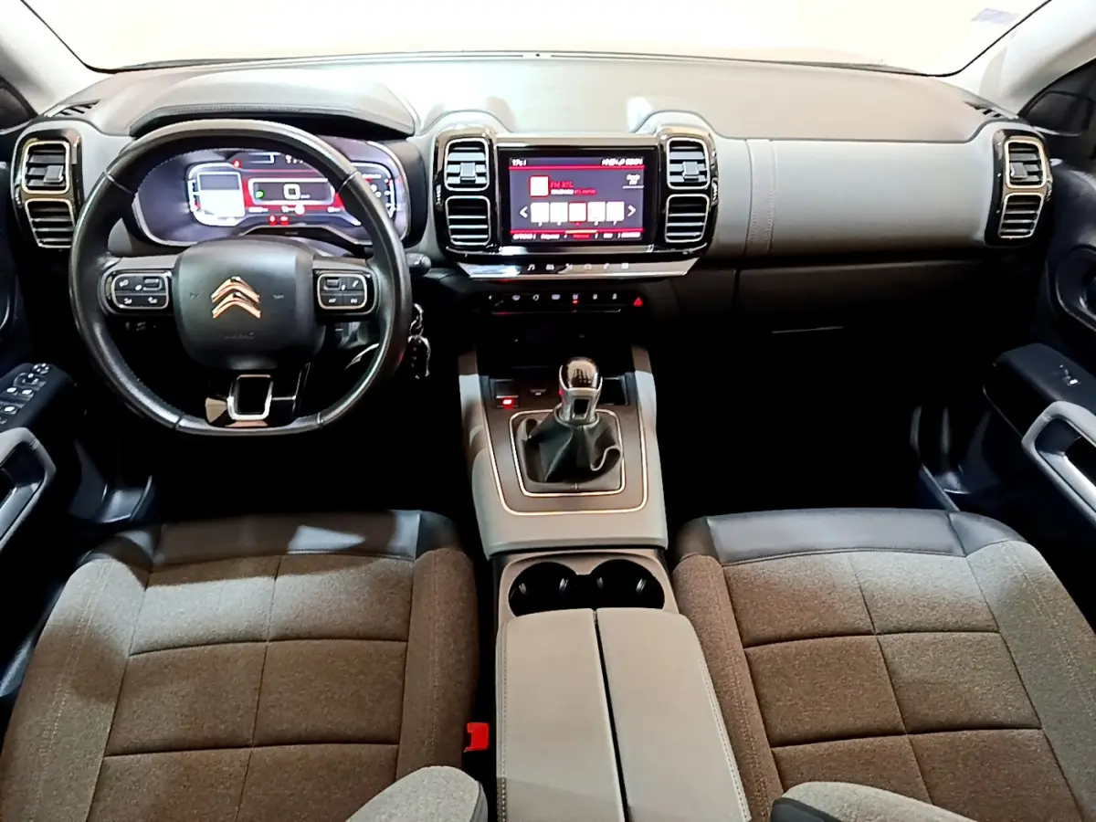 Vue intérieure avant du Citroën C5 Aircross 2020, montrant le volant cuir noir, tableau de bord numérique et console centrale grise.