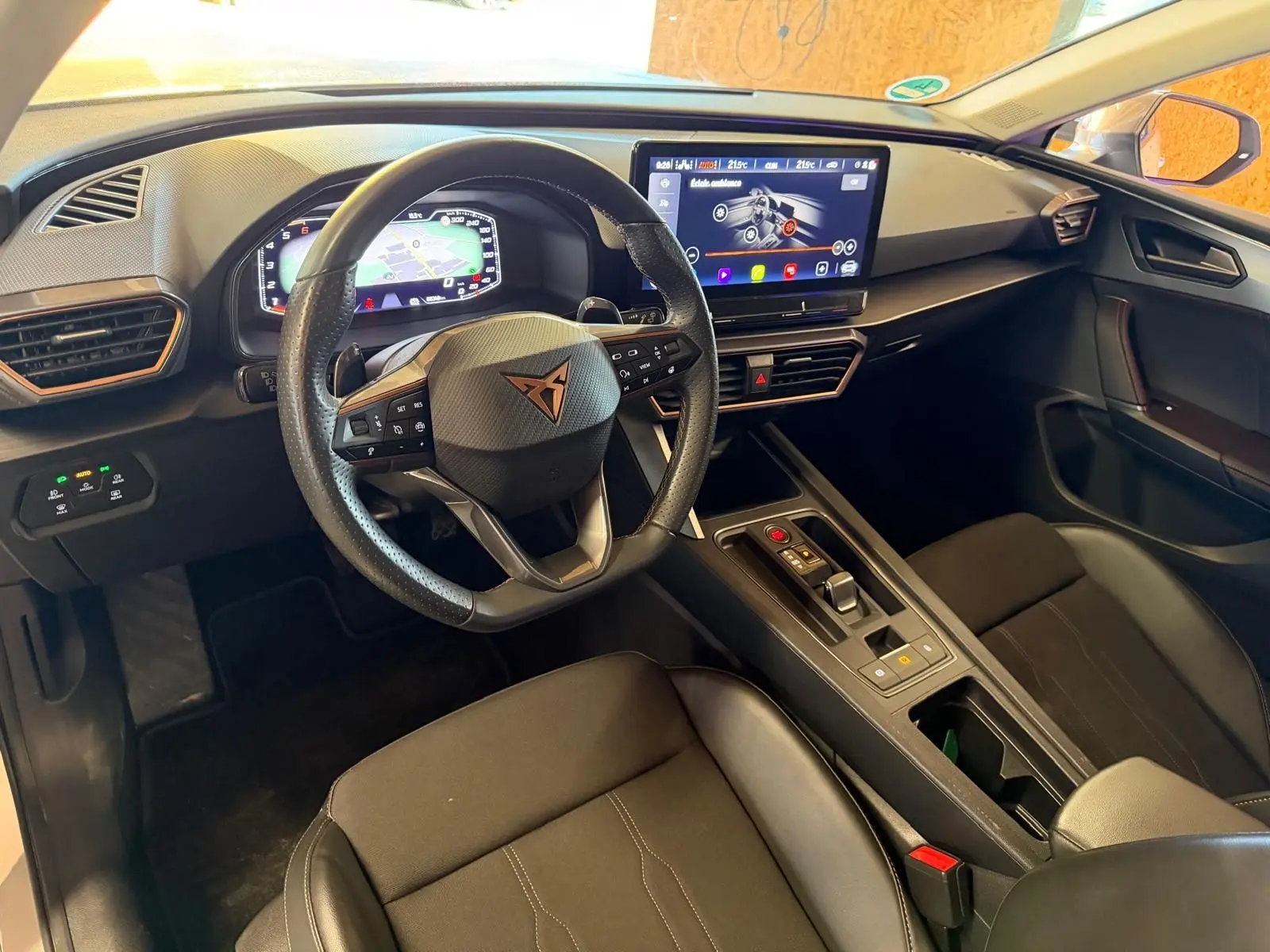 Vue intérieure côté conducteur de la CUPRA LEON ST 2024 avec tableau de bord numérique et écran tactile central.