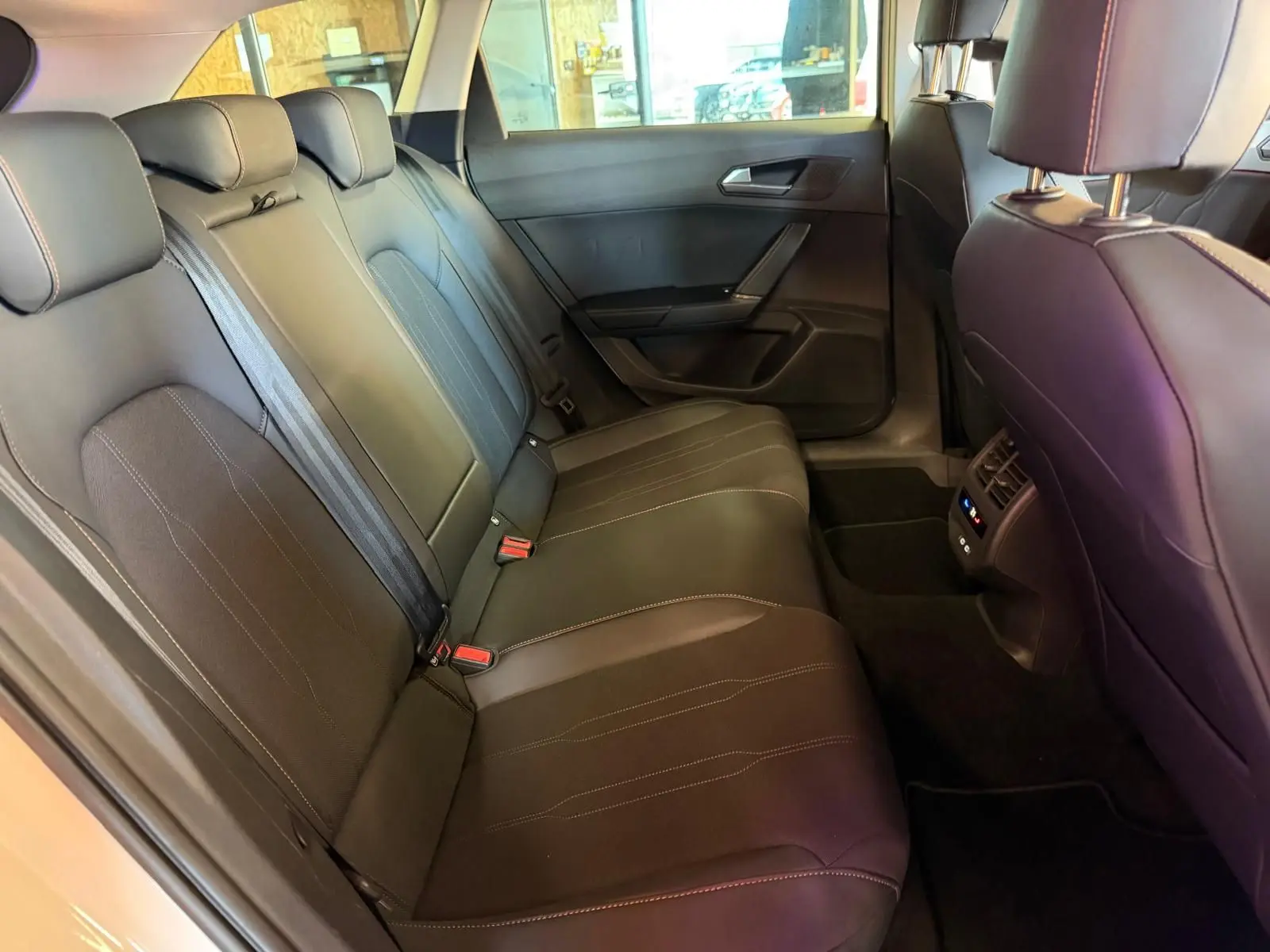 Vue intérieure de la banquette arrière en cuir noir de la CUPRA LEON ST 2.0 TDI 150 DSG7 V 2024, avec aérateurs arrière visibles.