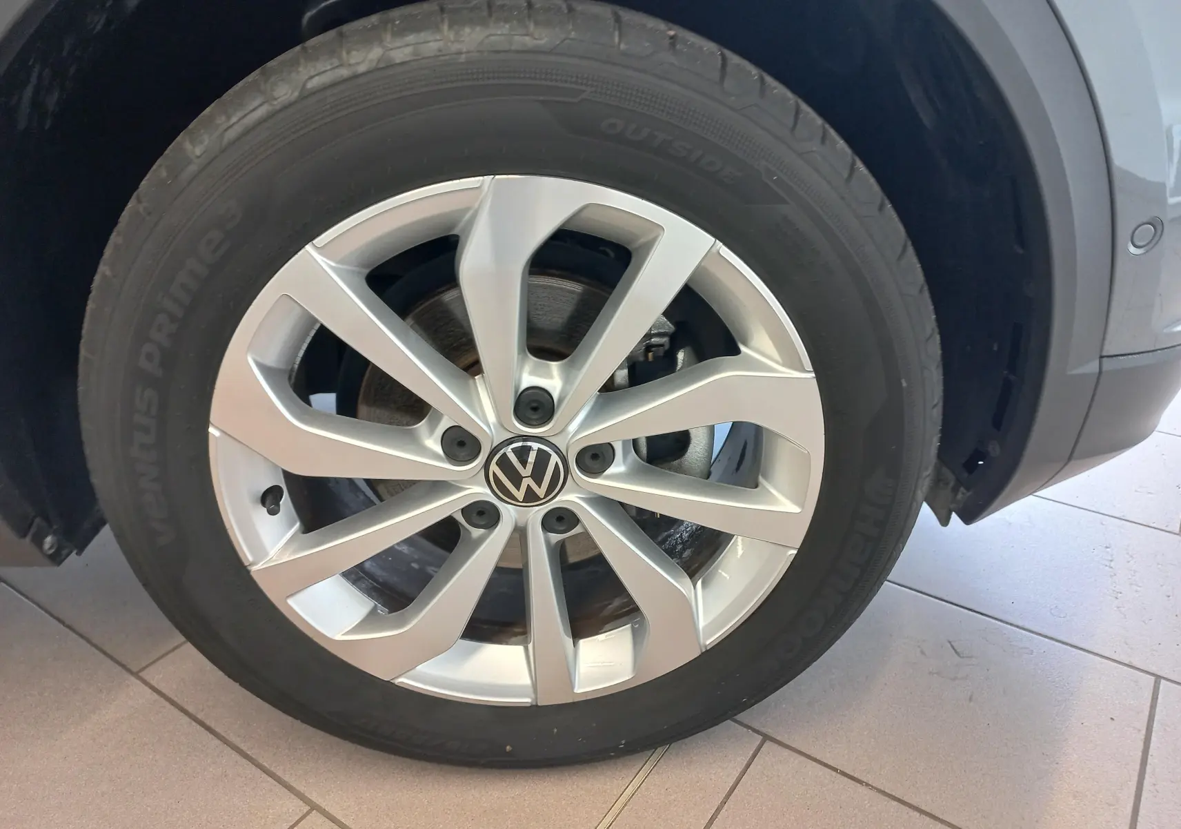 Gros plan sur la jante alliage argentée et le pneu Hankook d’un Volkswagen T-Roc gris Indium, roue avant droite.