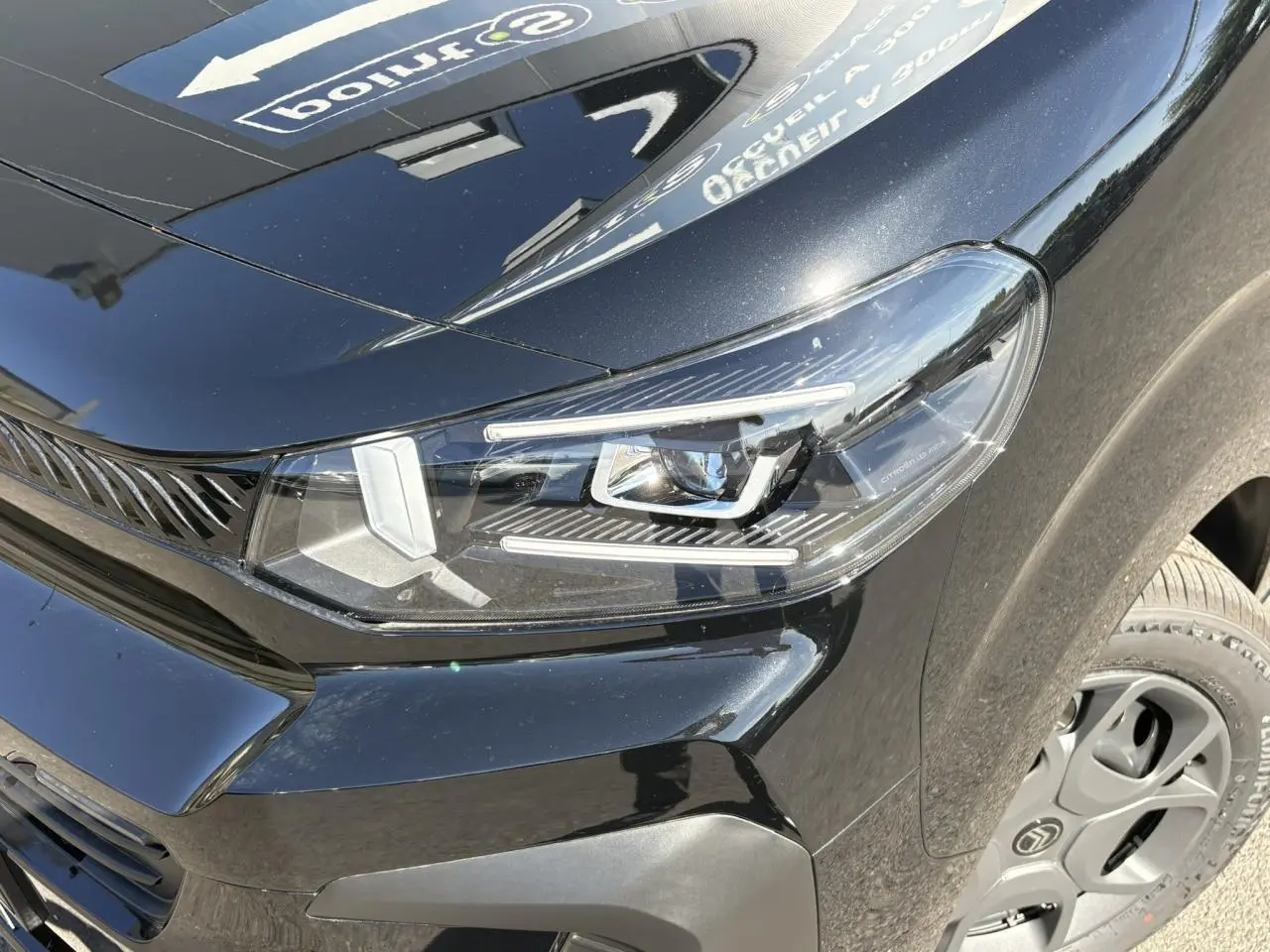 Gros plan sur le phare avant droit du Citroën Jumpy noir Perla avec jante tôle 17'' noire et détails du bouclier.