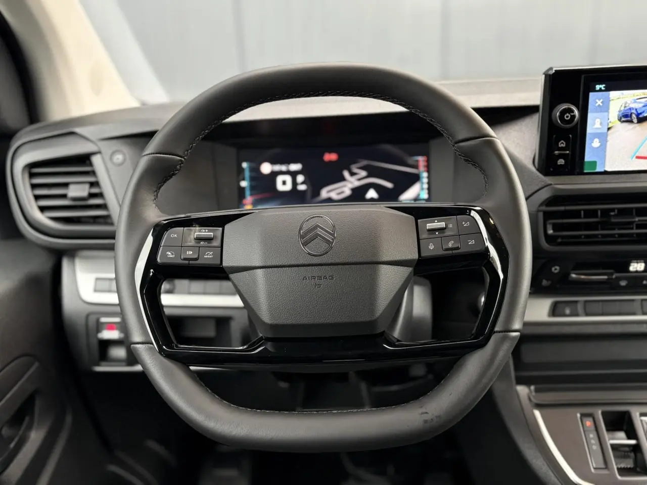 Vue rapprochée du volant noir de la Citroën Jumpy 2026 avec commandes intégrées et écran tactile en arrière-plan.