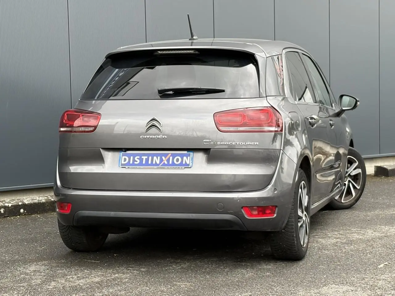 Vue 3/4 arrière droite d'une Citroën C4 Spacetourer gris foncé avec hayon électrique et jantes alliage 17 pouces.