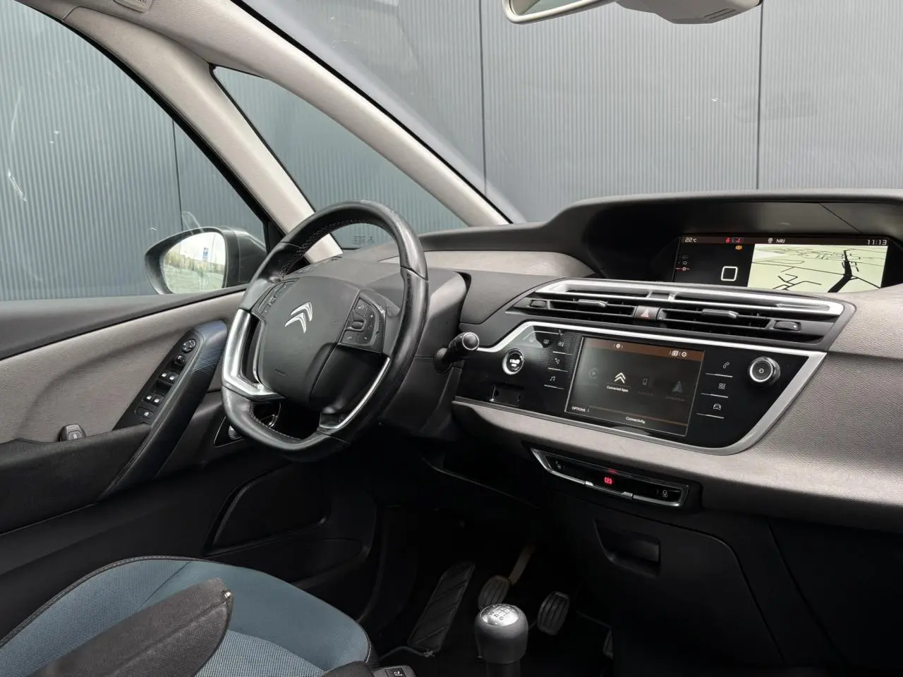 Intérieur avant gauche du Citroën C4 Spacetourer gris foncé, volant cuir, tableau de bord avec écran tactile et navigation.